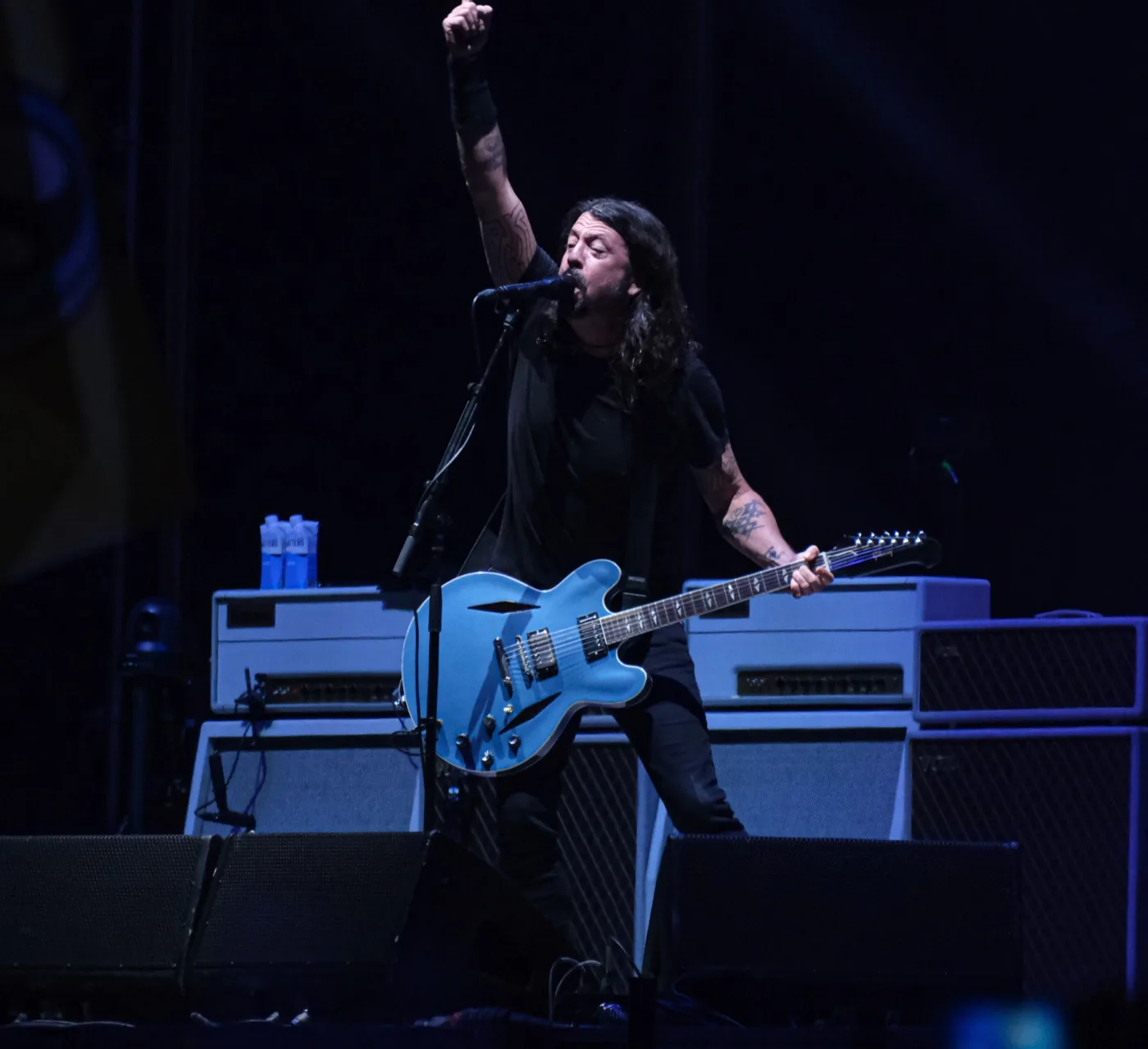 Dos envases de Water Matters sobre el amplificador, en el escenario de un concierto de Foo Fighters