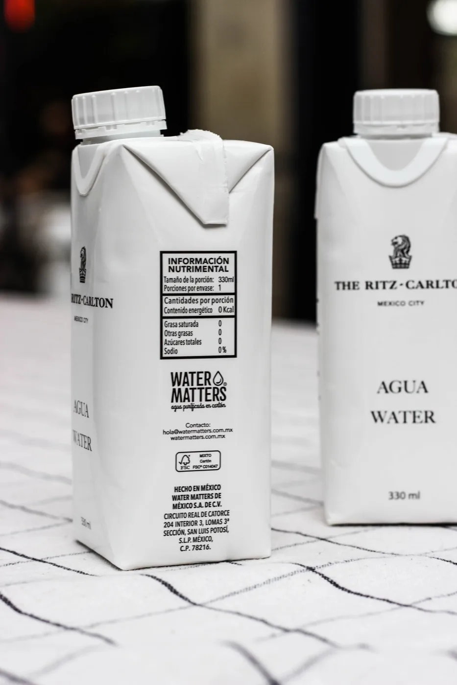 Envases de Water Matters personalizados para The Ritz-Carlton, en la mesa del restaurante