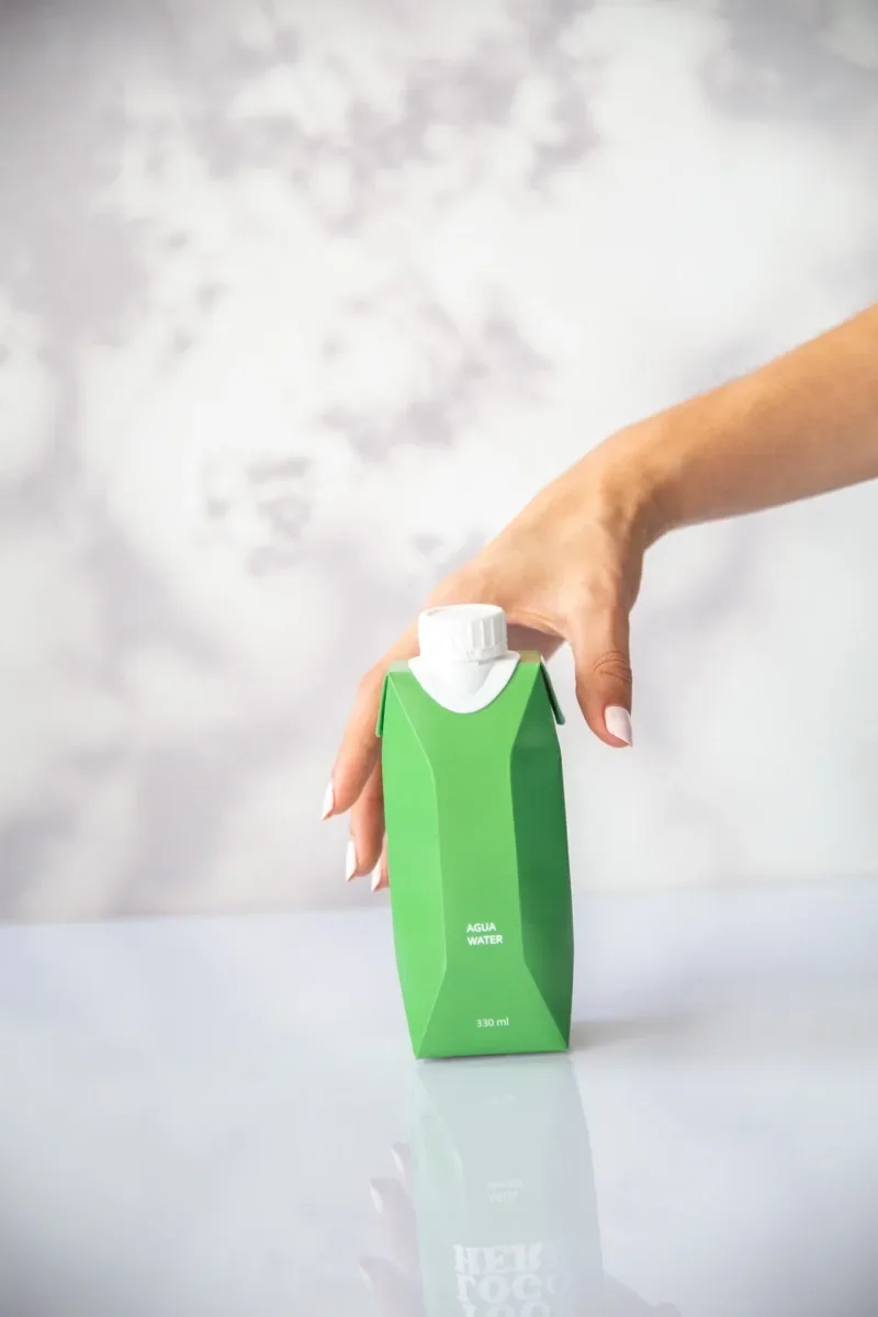 Envase de Water Matters sostenido en la mano, con el panel del logo en blanco