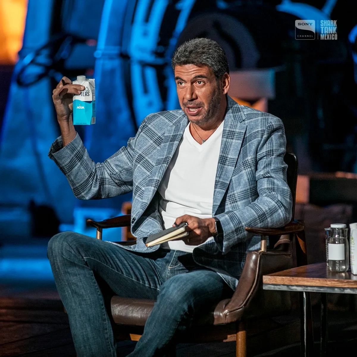 Un inversionista de Shark Tank México sostiene un envase de Water Matters en el set